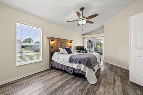 a spacious bedroom with a bed and wooden floor