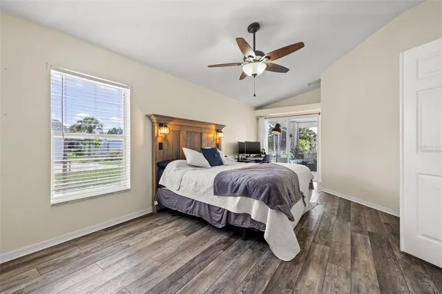 a spacious bedroom with a bed and wooden floor