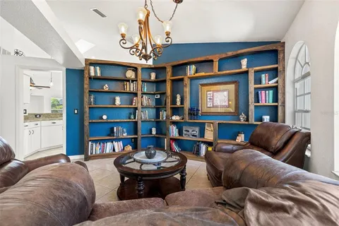 a living room with furniture and a book shelf