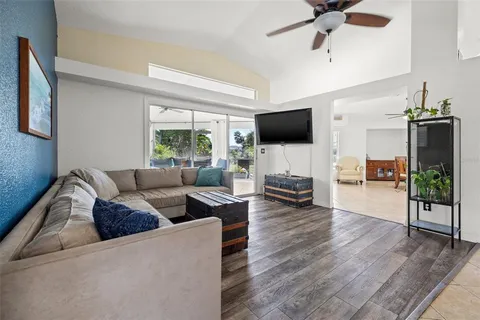 a living room with furniture a flat screen tv and a large window