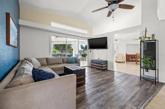 a living room with furniture a flat screen tv and a large window