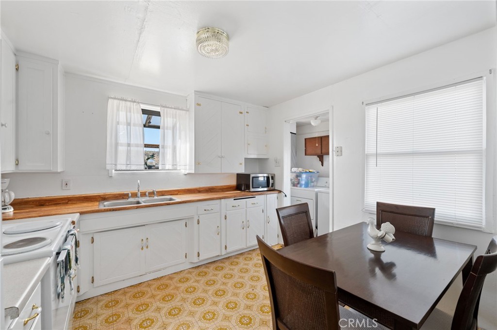 28074 Waterman Road Barstow, CA 92311 - Photo 14 of 25 a kitchen with a table chairs sink and cabinets