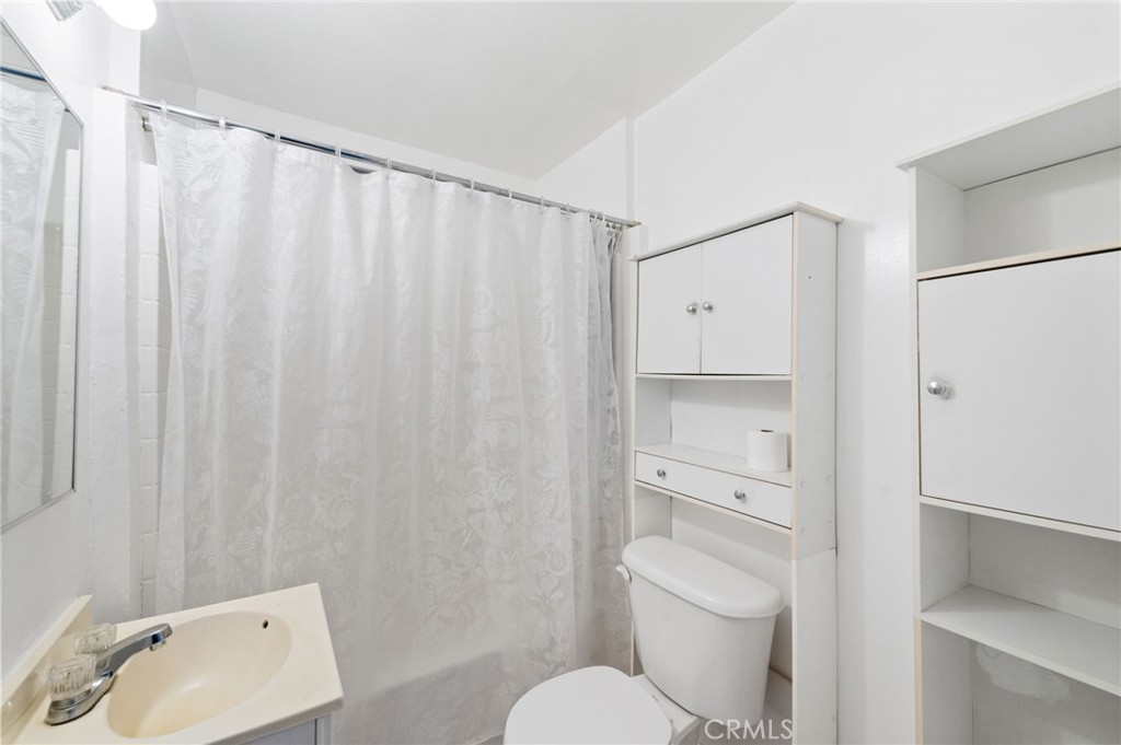 28074 Waterman Road Barstow, CA 92311 - Photo 21 of 25 a bathroom with a toilet and a shower curtain