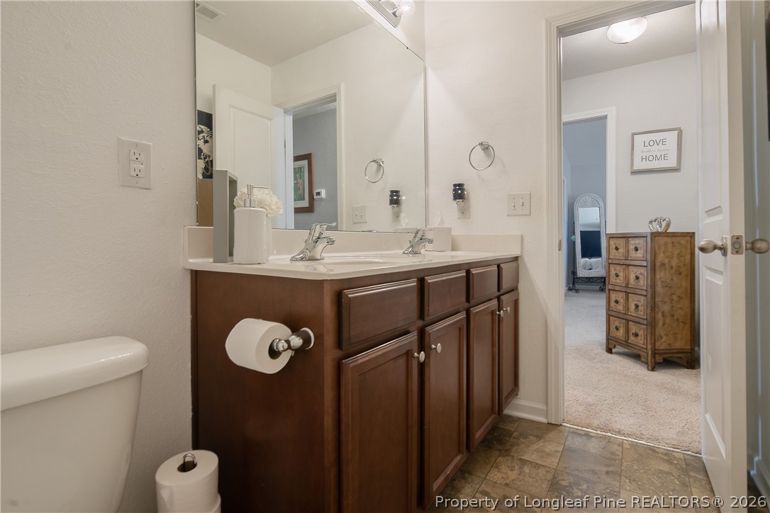 340 Battery Way Bunnlevel, NC 28323 - Photo 38 of 50 a bathroom with a toilet a sink and mirror