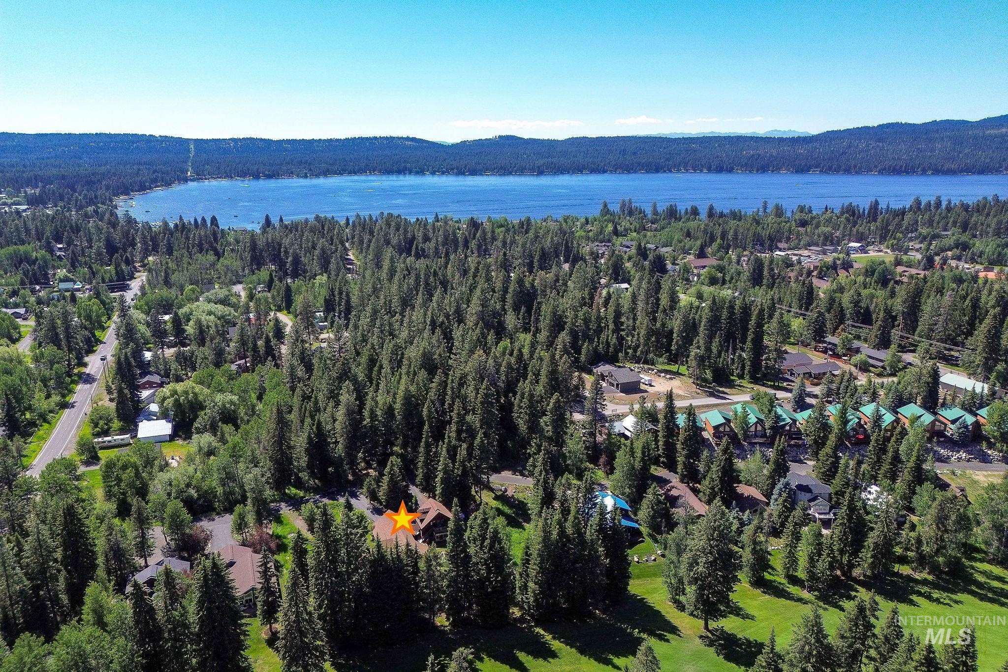 1345 Divot Lane McCall, ID 83638 - Photo 3 of 13 Aerial perspective showcasing a residential property nestled within a dense forest, surrounded by tall evergreen trees