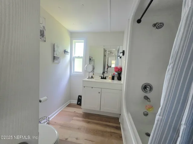 a bathroom with a sink vanity granite tub and shower