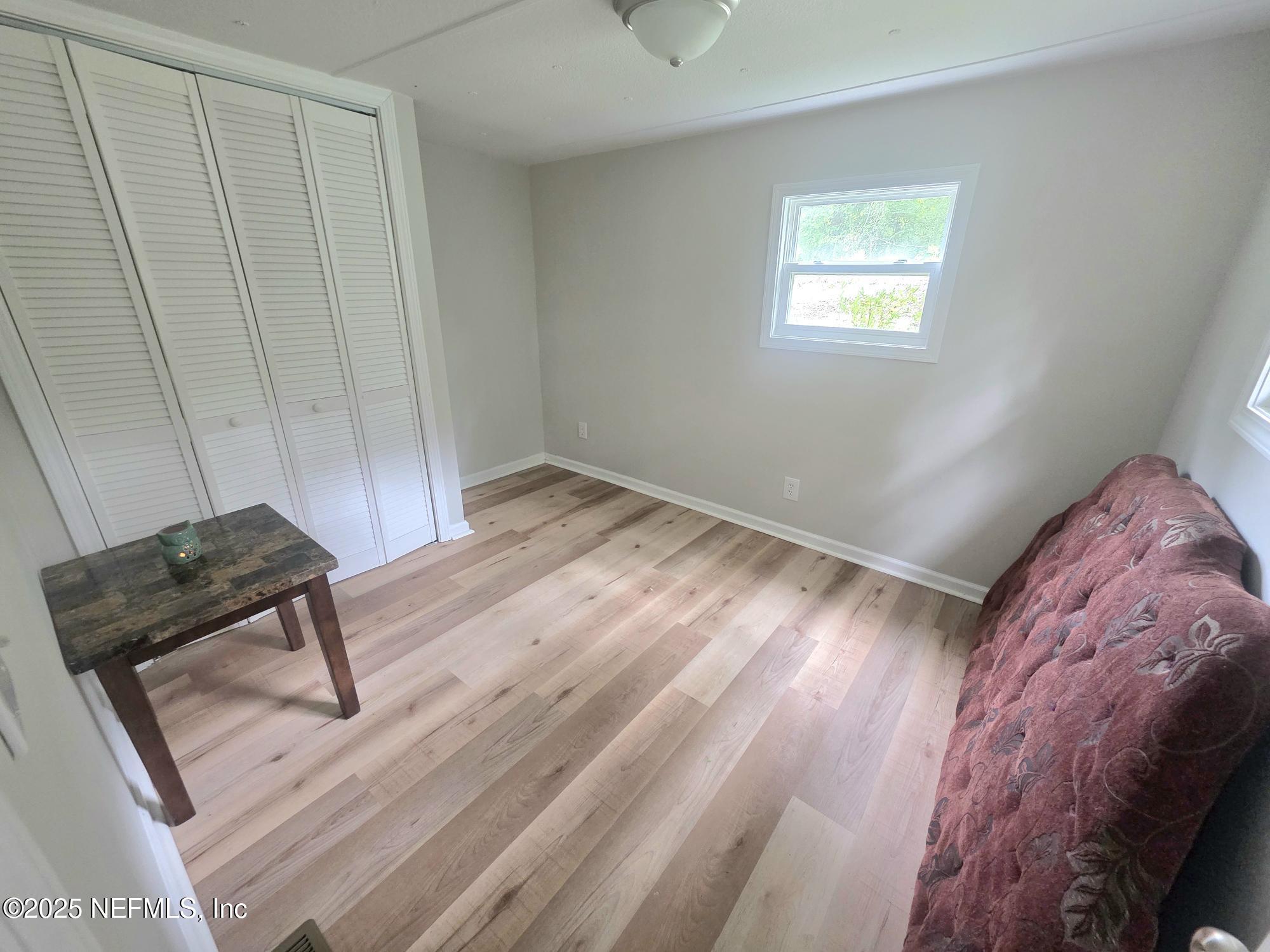 9332 Cedar Road Macclenny, FL 32063 - Photo 17 of 35 a view of a bedroom with wooden floor and a ceiling fan