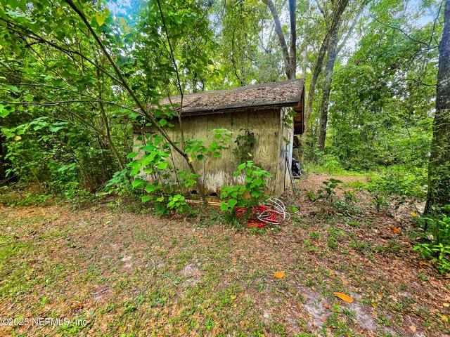 a view of a field with a trees in the background