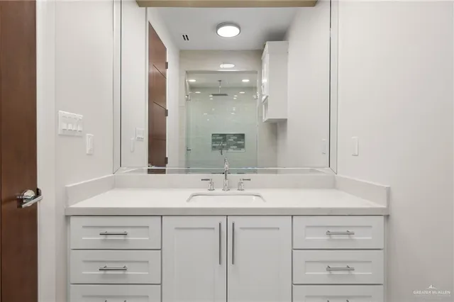 a bathroom with a sink vanity and a mirror