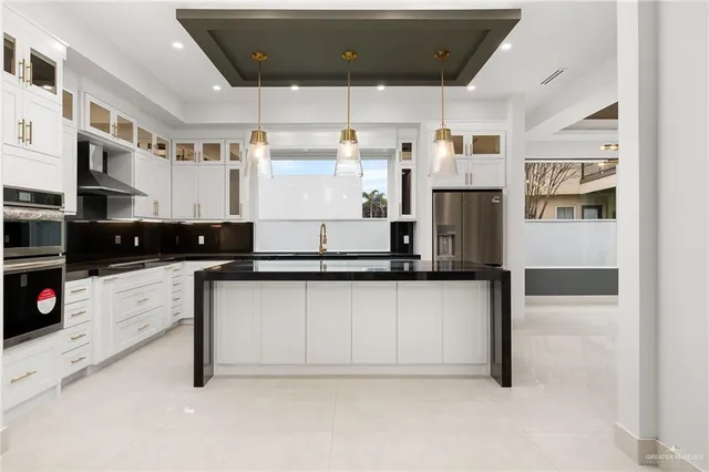 a kitchen with stainless steel appliances granite countertop a stove a sink and a refrigerator