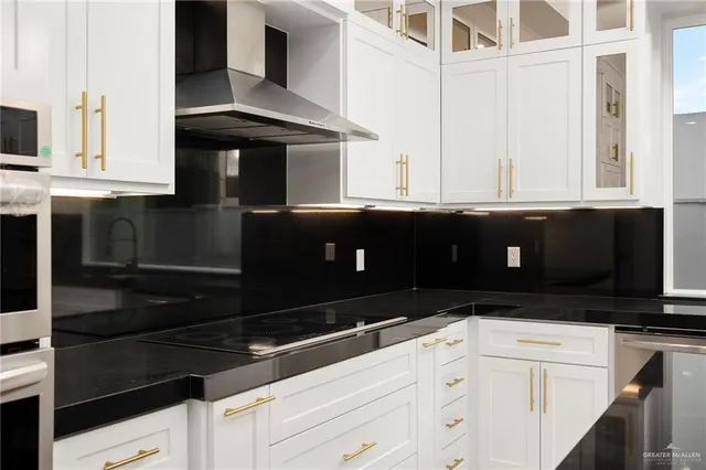 a kitchen with granite countertop white cabinets and black appliances