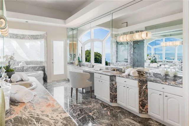 a large white kitchen with a sink and cabinets