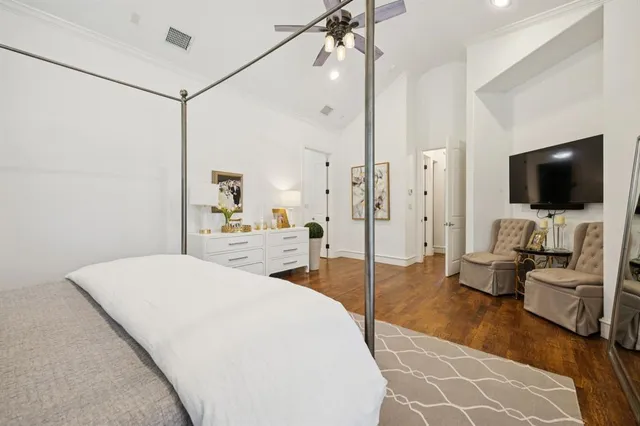 a spacious bedroom with a bed and a flat screen tv