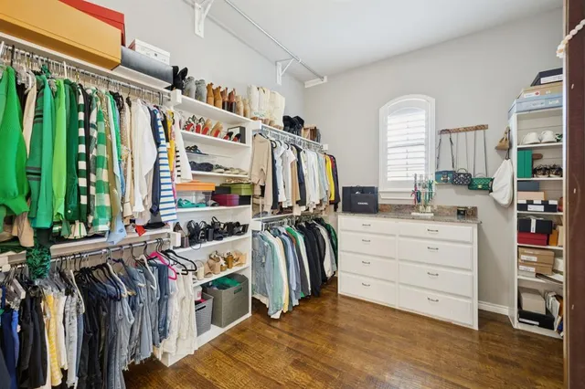 a view of walk in closet with clothes and shoes