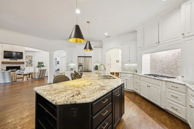 a kitchen with stainless steel appliances granite countertop a kitchen island a stove and a sink