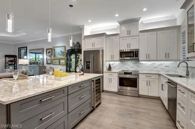 a kitchen with stainless steel appliances granite countertop a sink stove and refrigerator