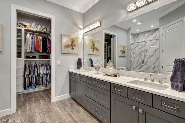 9637 Montelanico Loop, Unit 203 Naples, FL 34119 - Photo 23 of 50 Featuring double sink vanity, quartz counter, and view of custom built walk-in closet