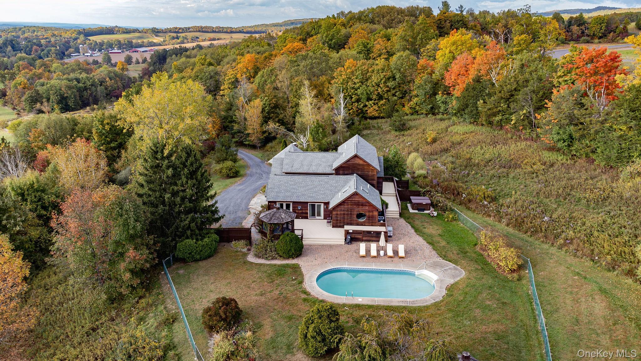View from above of property with a pool and a forest