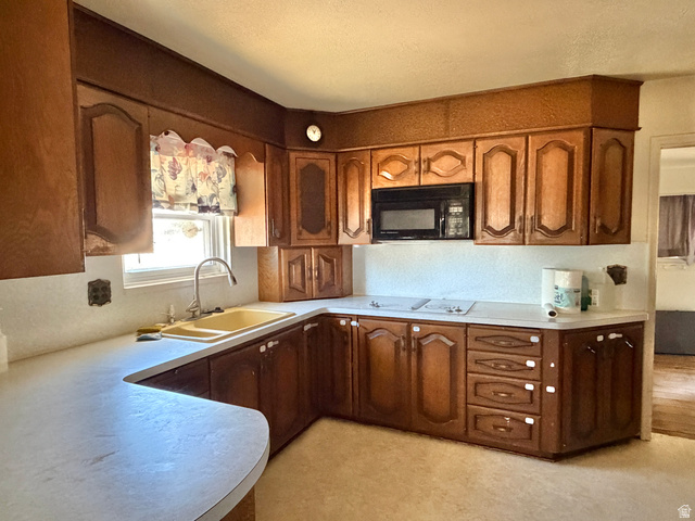 196 North 5th West Price, UT 84501 - Photo 8 of 27 Kitchen featuring wood-finish cabinetry, light-toned countertops, and a built-in microwave