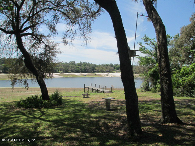 6444 Brooklyn Bay Road Keystone Heights, FL 32656 - Photo 23 of 32 a view of a lake with a tree in the background