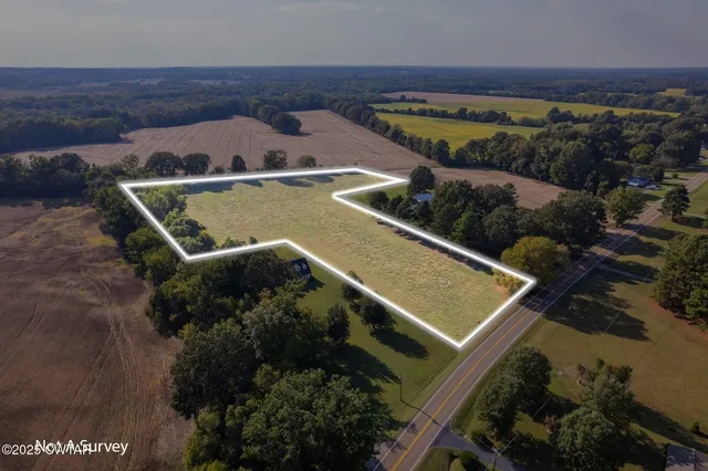 an aerial view of a house with a garden and lake view