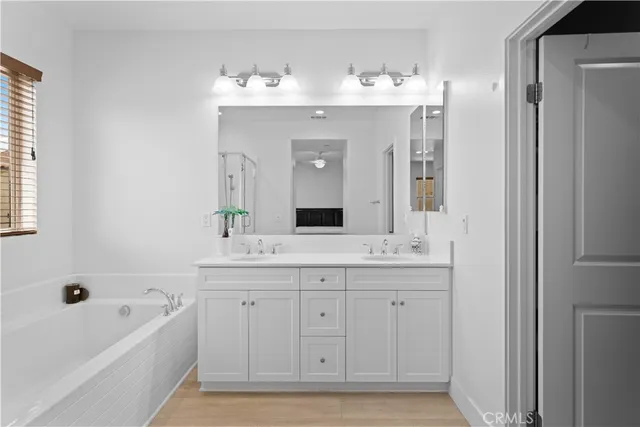 a spacious bathroom with a granite countertop sink mirror and a bathtub