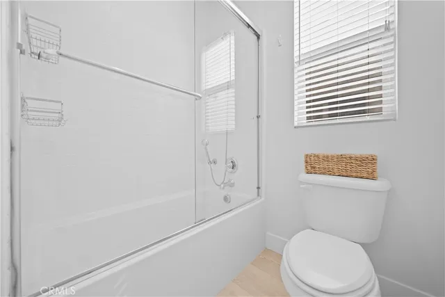 a white toilet sitting next to a bath tub