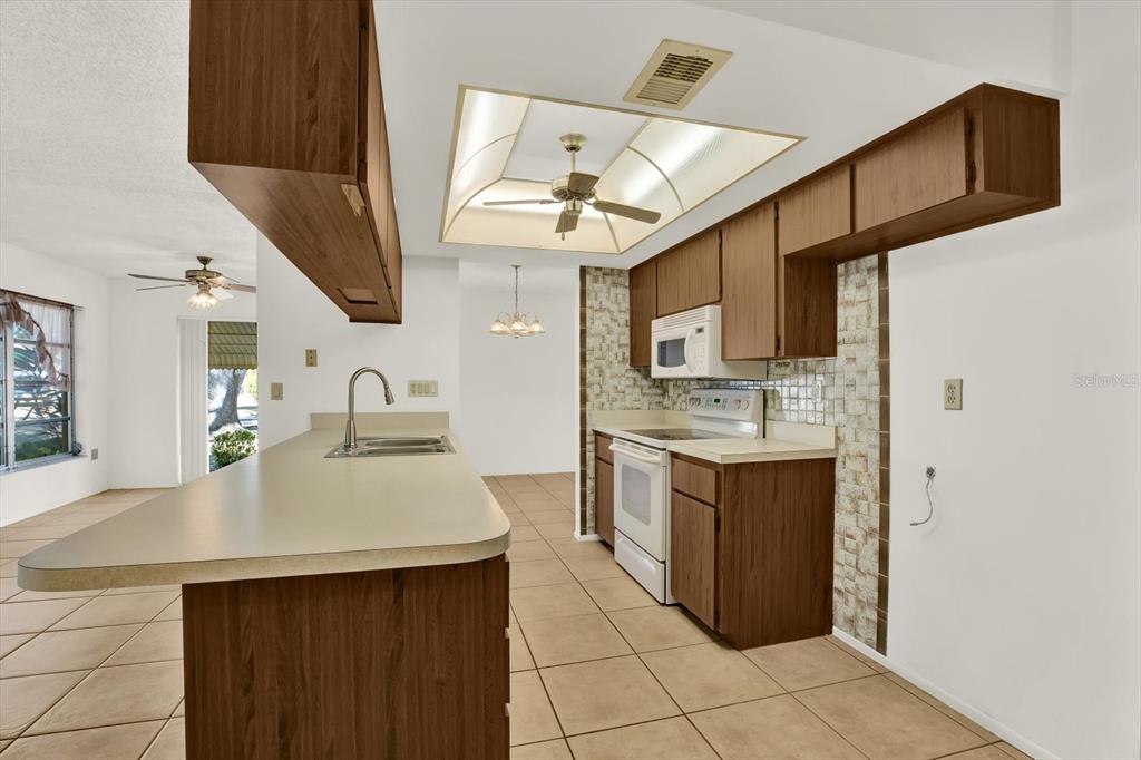 8410 Elgin Drive Port Richey, FL 34668 - Photo 13 of 37 a kitchen with stainless steel appliances granite countertop a sink and a refrigerator