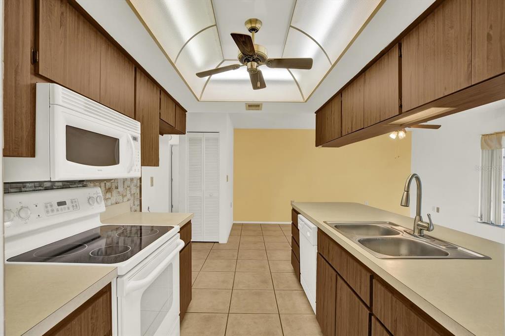 8410 Elgin Drive Port Richey, FL 34668 - Photo 16 of 37 a kitchen with stainless steel appliances granite countertop a sink a stove and a microwave oven with cabinets