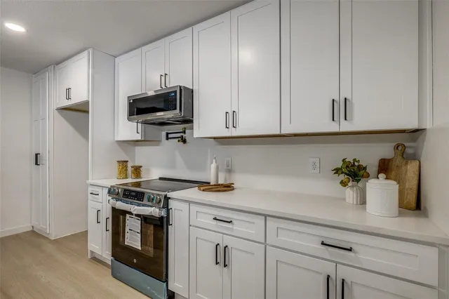 a kitchen with stainless steel appliances granite countertop a sink a stove and a microwave