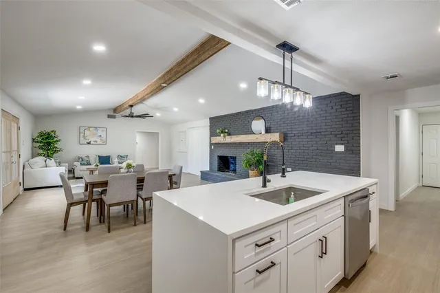 a view of kitchen island a chandelier and living room view