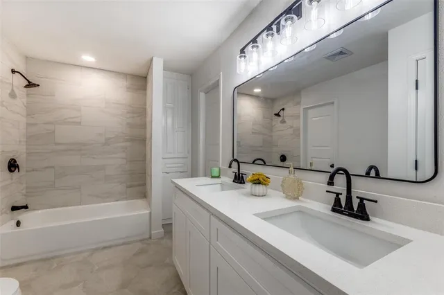 a bathroom with a bathtub a sink a mirror and a shower