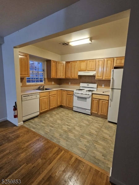 a kitchen with a stove top oven and refrigerator
