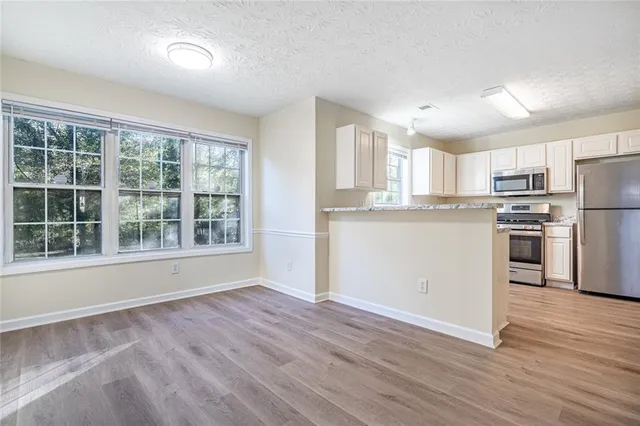 a view of kitchen with wooden floor and electronic appliances