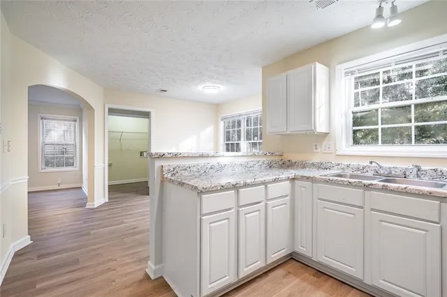 a kitchen with granite countertop sink and cabinets
