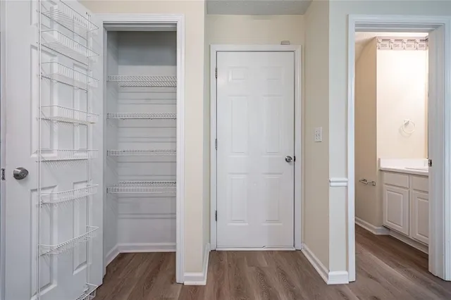a view of a hallway with wooden floor and closet area