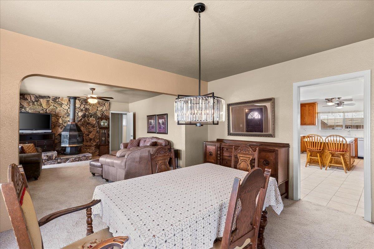 4701 Lone Tree Road Valley Home, CA 95361 - Photo 17 of 59 a bedroom with a bed a mirror on dresser and a chandelier