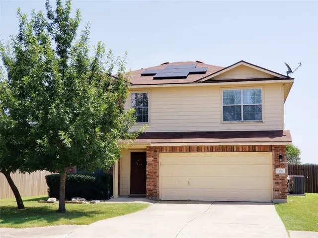 a front view of a house with a yard and a garage
