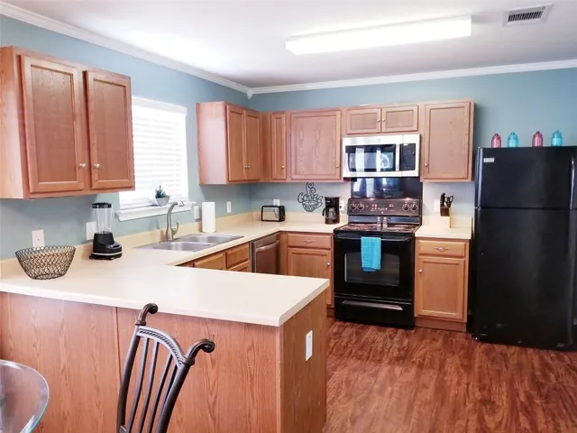a kitchen with a stove a refrigerator and a sink