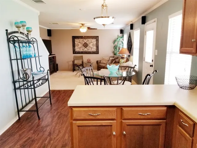 a view of a dining room with furniture a kitchen and wooden floor