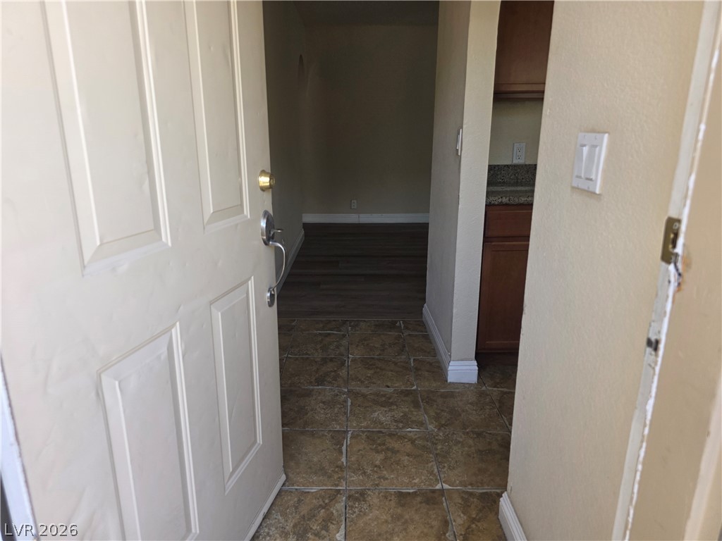 1844 North Decatur Boulevard, Unit 204 Las Vegas, NV 89108 - Photo 3 of 21 An open doorway reveals tiled entry flooring transitioning to wood finishes inside.