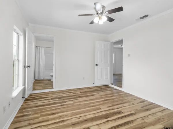 a view of a livingroom with wooden floor and a ceiling fan