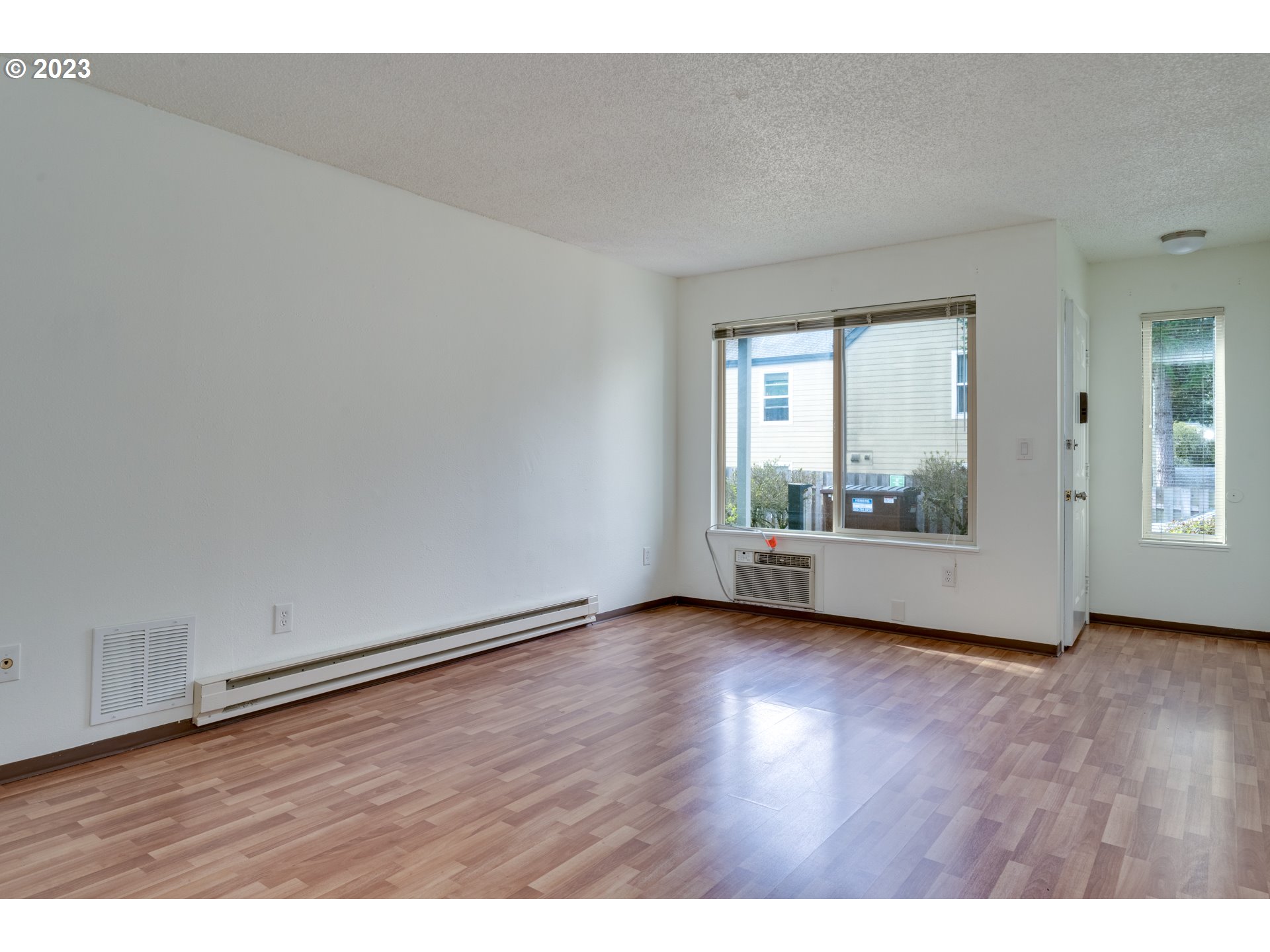 8421 Southwest 30th Avenue Portland, OR 97219 - Photo 11 of 28 a view of an empty room with wooden floor and a window