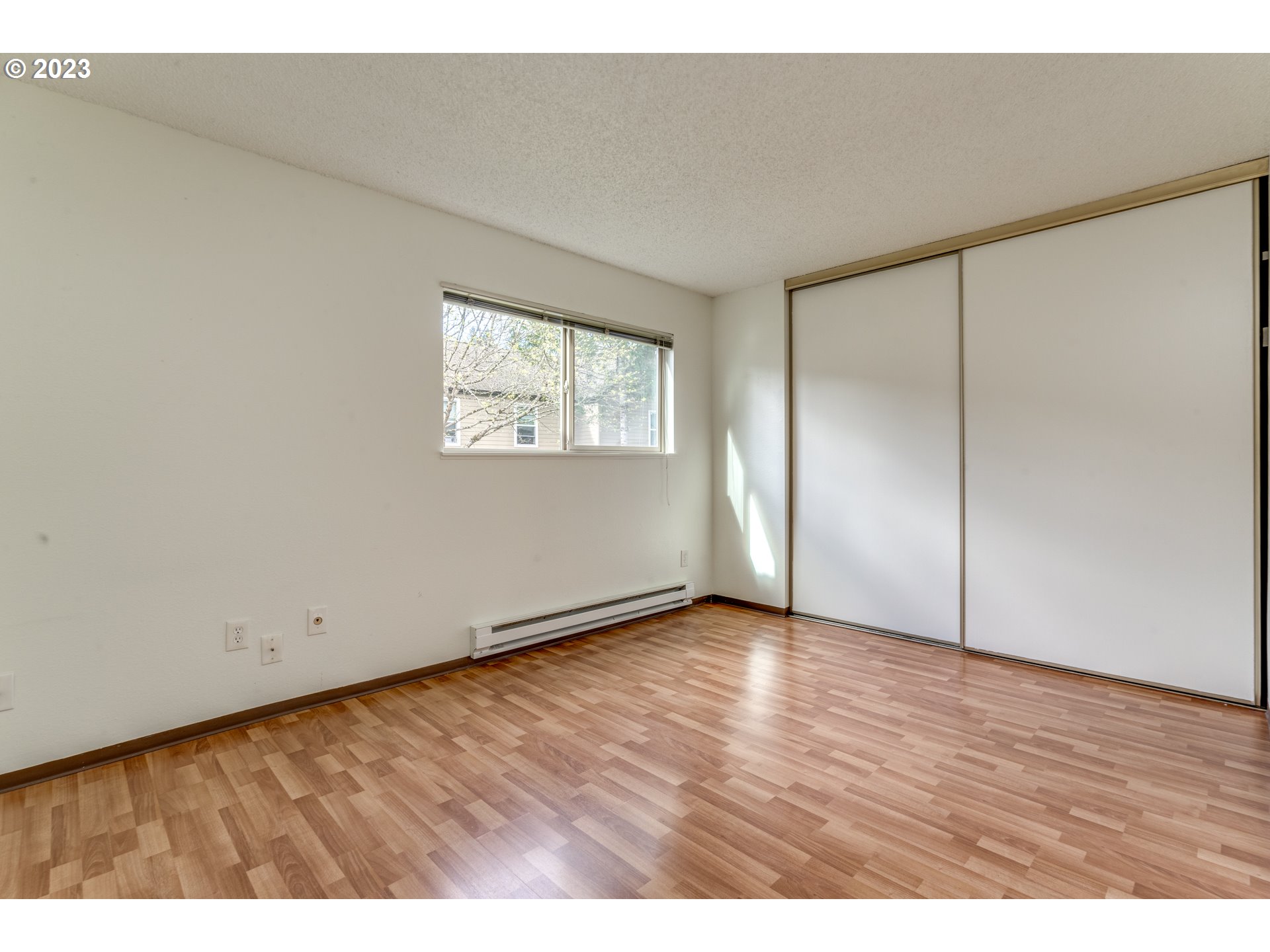 8421 Southwest 30th Avenue Portland, OR 97219 - Photo 13 of 28 a view of an empty room with wooden floor and a window