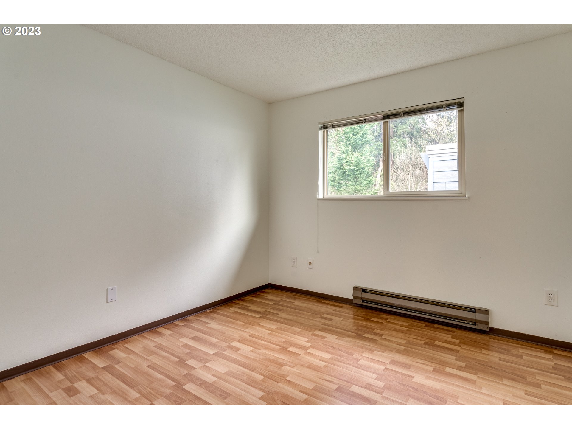 8421 Southwest 30th Avenue Portland, OR 97219 - Photo 18 of 28 an empty room with wooden floor and windows