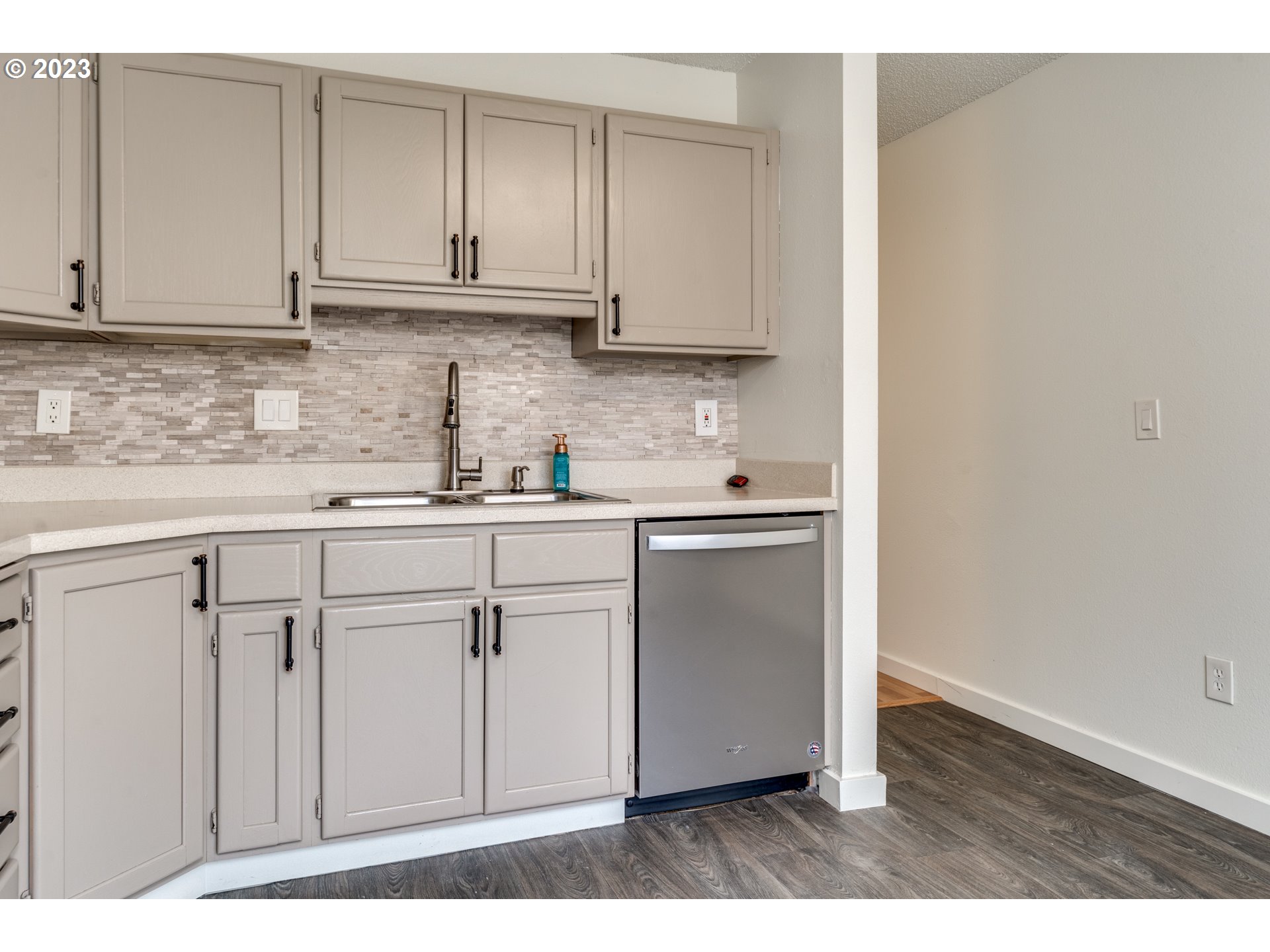 8421 Southwest 30th Avenue Portland, OR 97219 - Photo 7 of 28 a kitchen with stainless steel appliances granite countertop a sink and dishwasher with white cabinets