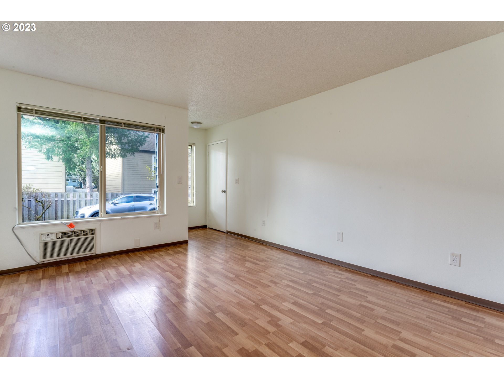 8421 Southwest 30th Avenue Portland, OR 97219 - Photo 8 of 28 a view of an empty room with wooden floor and a window