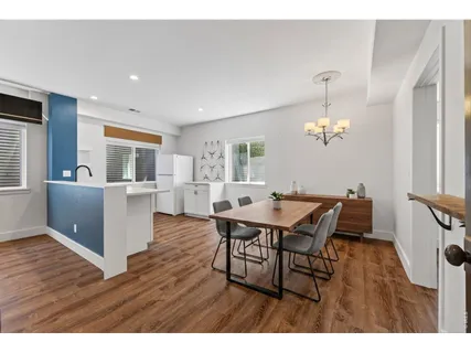 a dining room with furniture a chandelier and wooden floor
