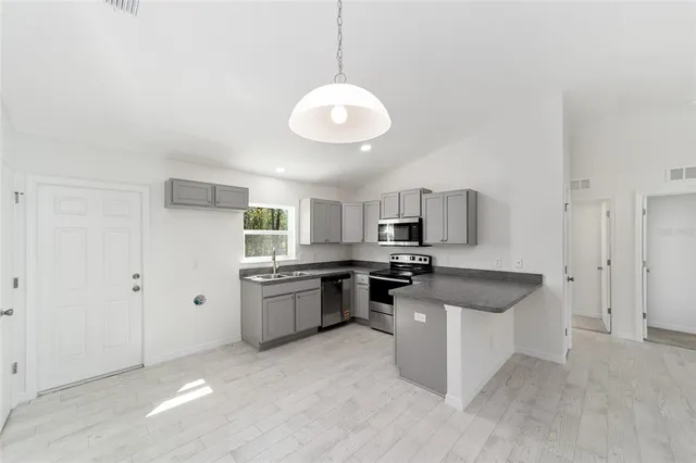 a kitchen with stainless steel appliances granite countertop a sink a stove and a refrigerator