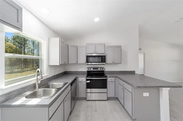 a kitchen with granite countertop a sink stove and refrigerator